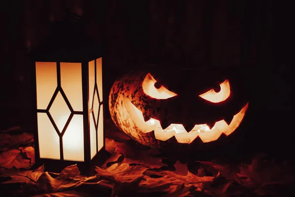 Halloween pumpkin head jack-o-lantern and illuminated lantern on black background. Spooky, creepy, atmospheric symbol of autumn holiday - halloween