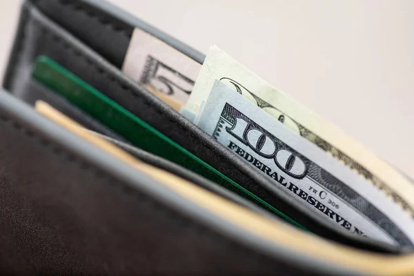 US money and banking card in a wallet, close up. Dollar banknotes as a worldwide currency, wealth, income and payments concept