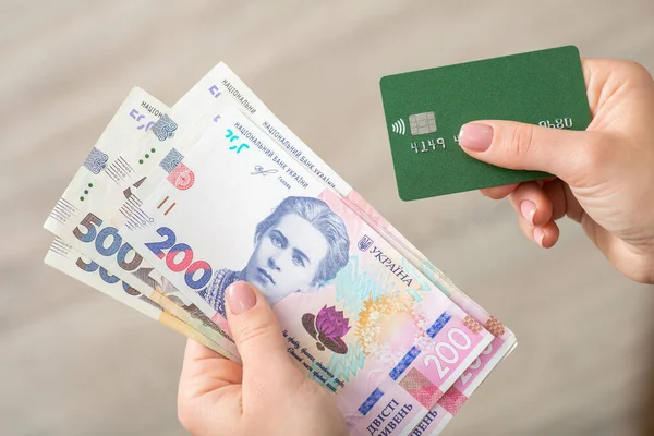 Ukraynalı Hryvnia 200 banknot ve kredi kartı kadınların elinde. Bankacılık, ödeme, finans ve ekonomi kavramı