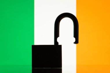 Flag of Ireland with silhouette of lock on the foreground. Reopen Ireland, open borders concept