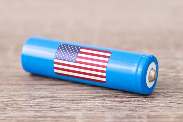 Close up of lithium battery with flag of USA on table. Production of li-ion batteries in USA concept