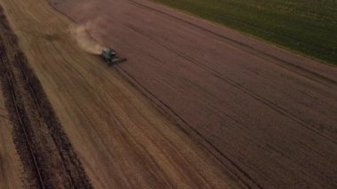 Akşamları tarlada çalışan tahıl hasatçısı. Buğday ya da çavdar hasadını birleştiren drone görüntüleri