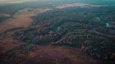 Kırsal kesimdeki bir nehrin su akıntısı sabah ilk güneş ışınlarıyla aydınlanıyor. Güzel doğanın sinematik videosu.