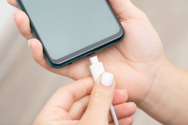 USB C kablosunu modern telefonun portuna bağla. Modern telefon yükleniyor, limana kablo yerleştiriliyor