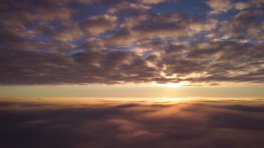 Parlak akşam bulutları arasında gökyüzünde güzel drone görüntüleri. Gün batımında gökyüzünde uçmak