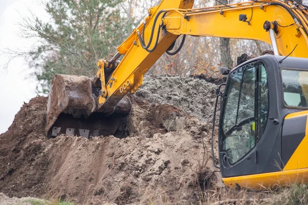 挖掘机逐渐铺开挖出的土 形成了一座大山 在农村工作的挖掘机 — 图库照片
