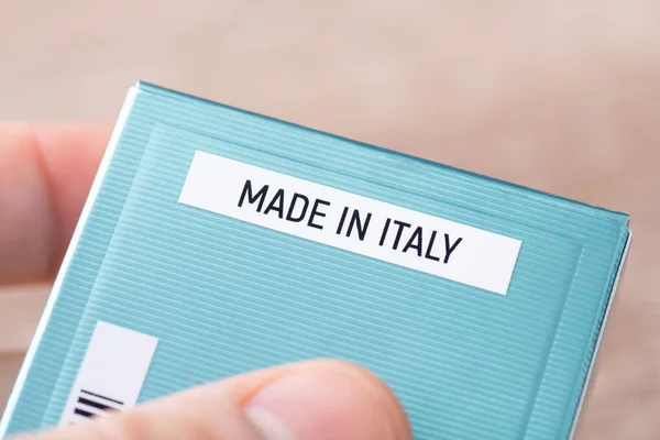 stock image Box with perfume in hands of a man, made in Italy inscription. Producing perfumes in Italy