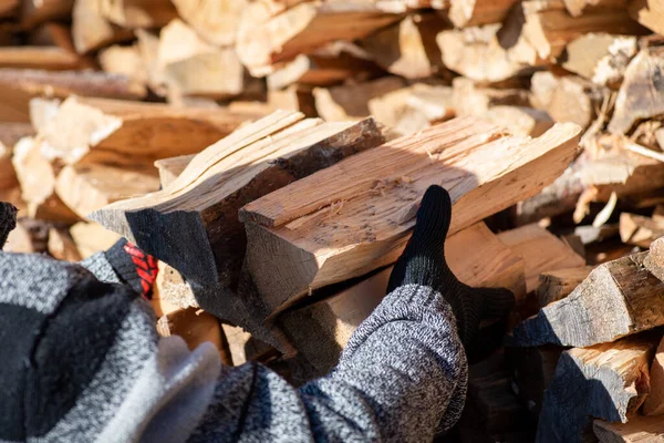 stock image Man taking some firewood for heating house. Heating home with wood during cold winter period