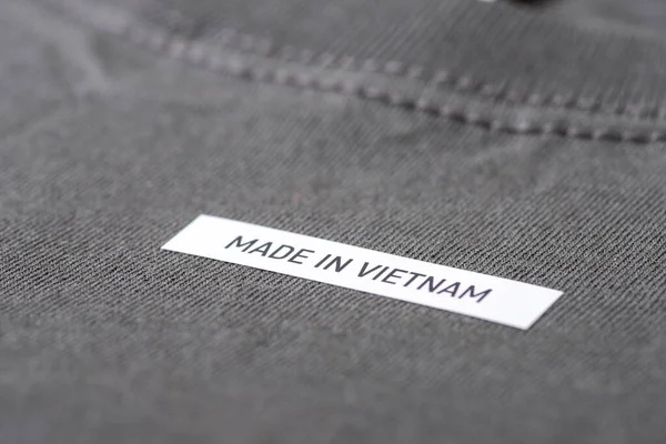 stock image Close up shot of inscription Made in Vietnam on dark grey T-Shirt. Concept of production of clothes in Asia, manufacturing, textile business