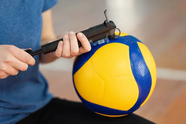 Eğitimden önce yeni voleybol topunu sahada elle pompalayarak şişiren kıza yaklaş. Antrenman ve voleybol müsabakaları için profesyonel top aldım.
