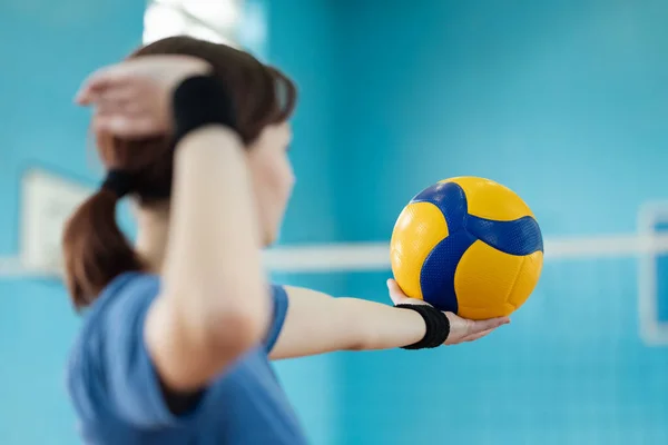 stock image Young girl player preparing to serve the volleyball to opponents side of the net. Female learner mastering skills in volleyball, practice serving