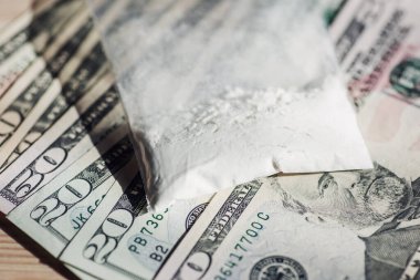 Amerikan doları banknotlarında kokain ya da başka uyuşturucularla dolu plastik torba. Uyuşturucu ticareti kavramı, tonlu fotoğraf