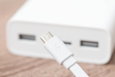 Ön planda mikro usb kablosu olan güç bankasını kapatın. Şarj cihazları için harici akıllı pil kullanılıyor