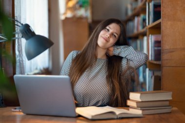 Dizüstü bilgisayarın başında saatlerce çalıştığı için yorgun öğrenci korkunç bir boyun ağrısı çekiyor. Sıkı eğitim, oturma tarzı nedeniyle sağlık sorunları