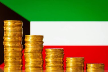 Flag of Kuwait with stacks of golden coins forming downcomming progression. Crisis in economy of Kuwait, negative process in finances of the country