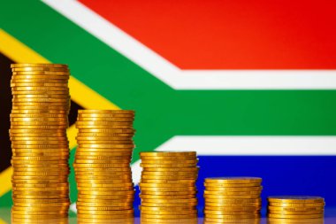 Arka planda Güney Afrika bayrağı olan altın sikkeler. Ekonomik çöküş kavramı, çöküş. Güney Afrika 'da olumsuz mali oran