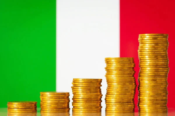 Flag of Italy with coins stacks from lowest to highest on the foreground. Development of Italy, financial profit, GDP positive level