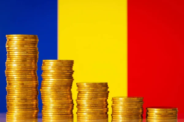 Stacks of gold coins from highest to lowest with flag of Romania on the background. Concept of economic decrease, fall, crash. Negative financial rate in Romania