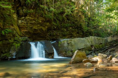 Ukrayna Karpatlar 'ında küçük bir şelale. Güneşli bir günde dağlardaki güzel şelale manzarası