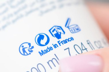 Fransız malı bir şampuan tüpü taşıyan bir kız. Fransa 'da şampuan üretimi