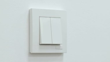 Odadaki ışıkları kapatıyorum. Beyaz parlak odada ışığı kapatan adam