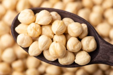 Koyu ahşap kaşıkta fındık yakın plan görüntüsü. Kaşıkla soyulmuş fındık.