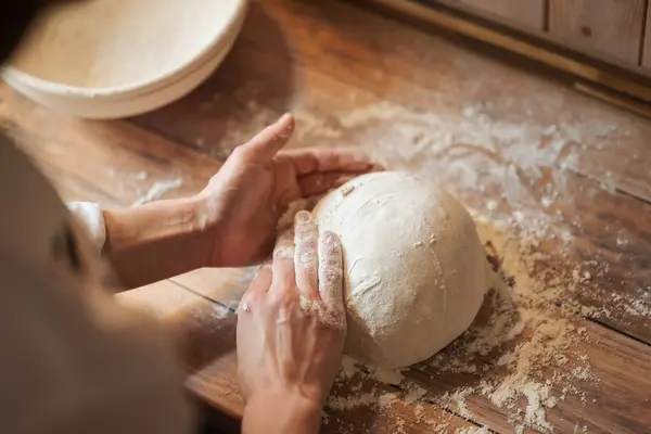 Girl baking bread at home. Hands of a girl hostess forming loaf of bread