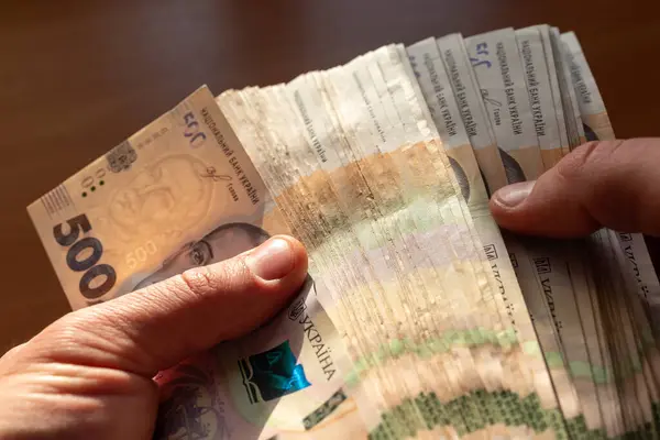 Erkek eller, Ukrayna 'nın 500 banknotunu tutuyor, sayıyor. İyi kazanç, servet, tasarruf ve ödeme kavramları