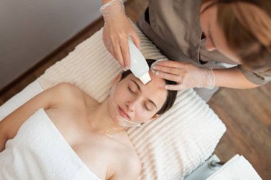 Ultrasonik cihazın yardımıyla yüzündeki gözenekleri temizlemek. Profesyonel güzellik prosedürü, cilt bakımı, kozmetik konsepti