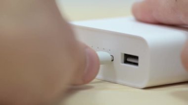 usb tip-c kablosu güç bankasına bağlanıyor ve kesiliyor. Modern hızlı usb c portu üzerinden şarj cihazları için power bank istasyonu kullanılıyor