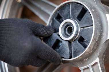 Arka motorsiklet tekerindeki lastik bantları değiştiriyorum. Motosiklet tamiri, motor bakımı, yıpranmış parçaları değiştirme, detaylar.