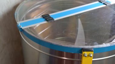 İş sırasında elektrikli bal çıkarma makinesi. Bal mevsimi hasadı, çerçeveli profesyonel özerk bal çıkarma makinesi.