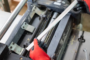 Joiner makinesine odun kesmek ve zımparalamak için yeni keskin bıçaklar yerleştiriyor. Profesyonel marangoz kaliteli iş aletlerini korur.