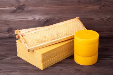 Çarşaf ve disklerde balmumu, tepedeki kovanın çerçevesi. Arıcılık konsepti, masada doğal balmumu.