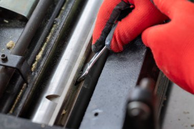 Kesmek için marangozluk makinesine yeni bir bıçak takmak. Eldivenli bir işçi marangozluk makinesine ahşap işçiliğini geliştirmek için yeni bir bıçak yerleştirir.