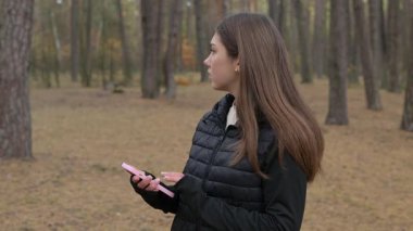 Kız ormanda yürüyor ve telefonundaki mesajı okuduktan sonra tedirgin oluyor. Sessiz bir ormanda gezinen bir kız telefonunu kontrol ederken ruh hali anksiyeteye dönüşüyor, etrafa korkmuş bir şekilde bakıyor.