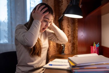 Şok olmuş genç bir kız ev ödevinden bunalmış. Ergen kız stresli, okul yüzünden şokta.