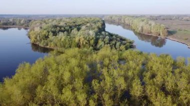Baharda yemyeşil sularla çevrili güzel bir nehir manzarası. İlkbaharda dalgalı yaprakların arasından süzülen bir nehrin nefes kesici manzarasını deneyimlemek doğanın güzelliğini gözler önüne seriyor.