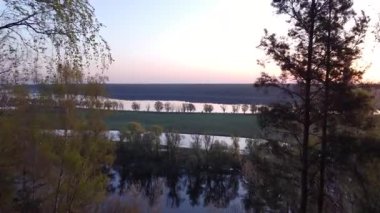 İlkbaharda sel basmış nehrin sabah manzarası bereketli manzaraları ortaya çıkarıyor. Sel basmış nehir vadisinin dingin güzelliği ve yemyeşil göller ve sakin su yansımaları.