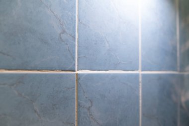 Bir odadaki el feneriyle açılmamış fayanslar. El feneri, bir odada döşeme arızaları olduğunu gösteriyor. Bu da yenileme sırasında çalışmanın kötü olduğunu gösteriyor.