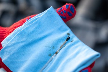 Motor yağı seviyesini dipstick ile kontrol ediyorum. Kırmızı eldivenli bir adam arabanın motor yağını kontrol ediyor.