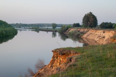 Bir sel sırasında Desna Nehri 'nin dik kıyılarının bahar manzarası. Desna Nehri 'nin yüksek kıyısında, bir sel sırasında, ağaçların ve gökyüzünün zeminine karşı resmedilmiş bir bahar manzarası.