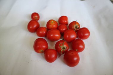 group of red ripe tomatoes on a white background.