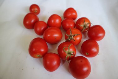 Group of red ripe tomatoes on a white background.