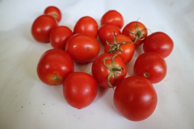 Group of red ripe tomatoes on a white background.