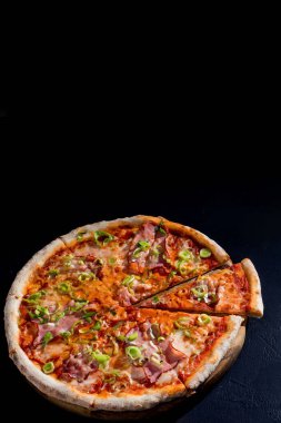 Mozarella peynirli, jambonlu, siyah arka planda domates soslu lezzetli pizza. Boşluğu Kopyala.