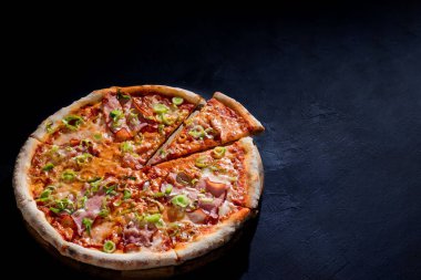 Mozarella peynirli, jambonlu, siyah arka planda domates soslu lezzetli pizza. Boşluğu Kopyala.