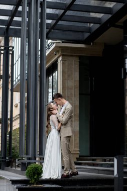 Gelin, damadın sevgi dolu gözlerine bakar. Gülümseyen yeni evliler birbirlerinin gözlerinin içine bakar.