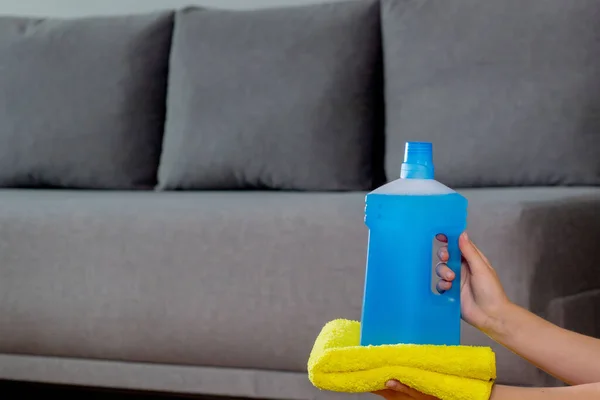 Cleaning agent in a plastic bottle with rag in hands. House cleaning