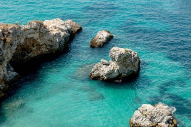Bird's eye view of the blue sea, rocks in clear water, azure beach. Beautiful landscape of the sea coast, stones in blue water, waves